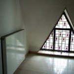 Triangular window above the front door. The colored glass is not dark at all.